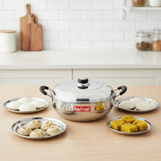 Stainless steel MaxFresh multi-purpose katta with lid and four plates of traditional Indian snacks on wooden kitchen counter